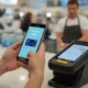 Person using Samsung Pay app on a smartphone to make a contactless payment at a store.