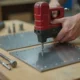 Using a rivet gun to join metal sheets on a DIY workbench