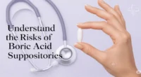 Woman’s hand holding a boric acid suppository capsule on a soft pink background, representing feminine health and the risks of boric acid suppositories.