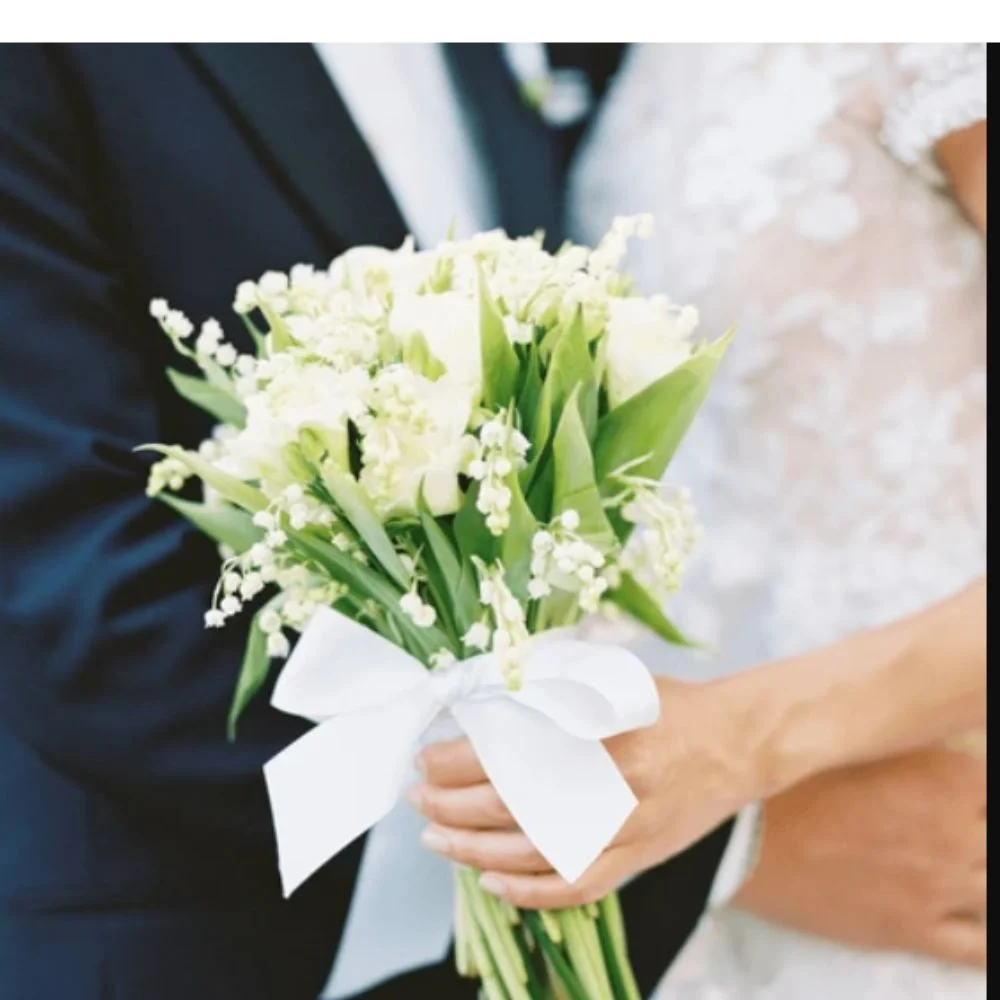 Bride and groom with matching floral designs in the bouquet and boutonnière using the same flowers and color palette