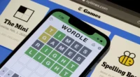 solving a NYT Mini Crossword on a tablet showing the clue “Pesky little twerp” with the answer